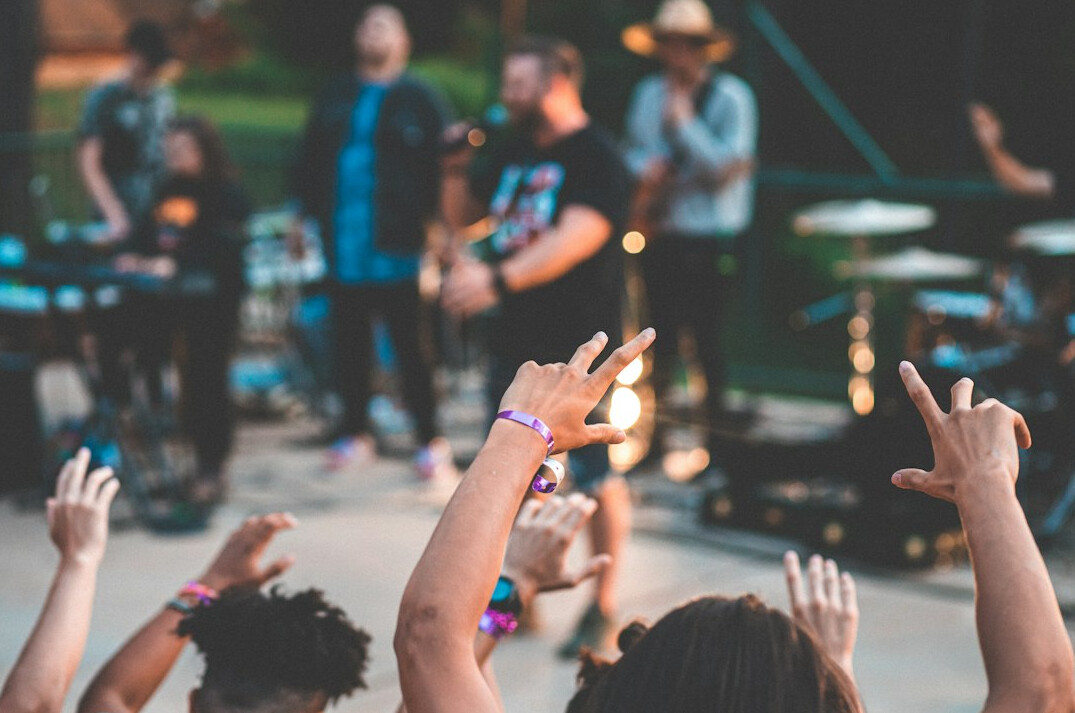 Crowd at an outdoor music event with raised hands